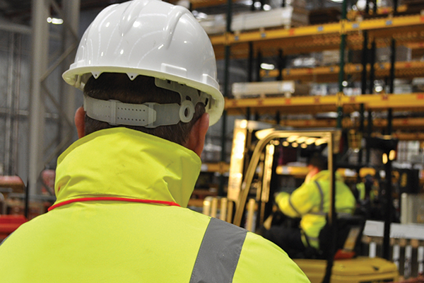 A manager overseeing forklift operators onsite