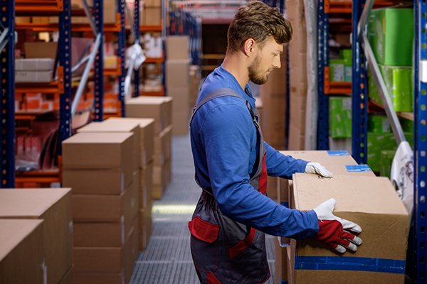 A worker lifting a box in a warehouse