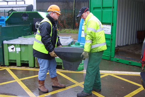Two people working onsite correctly lifting an item together