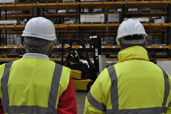 Two managers overseeing forklift operations