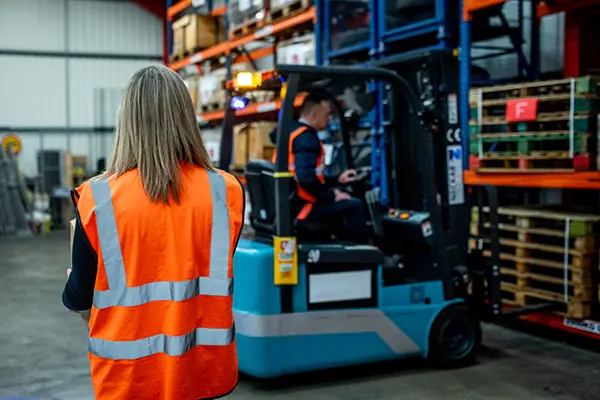 A pedestrian walking near a forklift truck